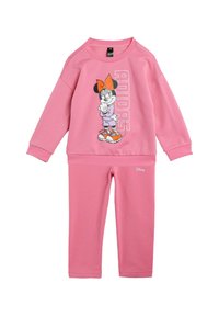 Rosa sweatshirt och byxor i set med en grafik av en karaktär med en orange rosett och skor, tillverkad av mjukt bomullsblandat material.