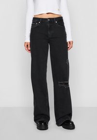 Black wide-leg jeans with distressed detailing, five pockets, belt loops, and a button closure, made from denim fabric.