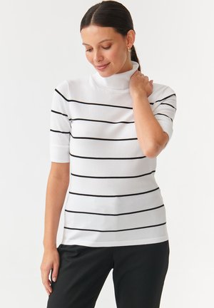 Weißer kurzärmeliger Rollkragenpullover mit schwarzen horizontalen Streifen, taillierte Passform, weiche Textur und Rippbündchen, kombiniert mit einer dunklen Hose.