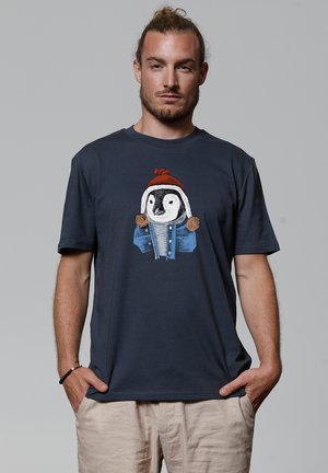 Navy katoenen T-shirt met een pinguïnprint die een rode hoed en een spijkerjack draagt. Korte mouwen en een relaxte pasvorm. Effen achterkant.