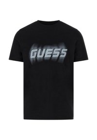 Zwarte katoenen t-shirt met korte mouwen, voorzien van een groot, vervaagd wit "GUESS" logo dat over de borst is gedrukt. Klassieke ronde hals.