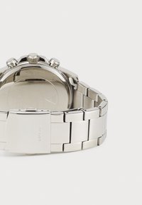 Montre-bracelet en acier inoxydable avec une finition brossée, dotée d'un design chronographe, de trois boutons-poussoirs et d'un fermoir sécurisé.