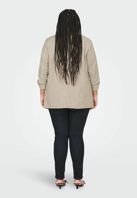 Beige linane pluus kolmeveerandvarrukatega, koos tumedate kitsaste teksade ja mustade sandaalidega, millel on leopardimustriga aksent.