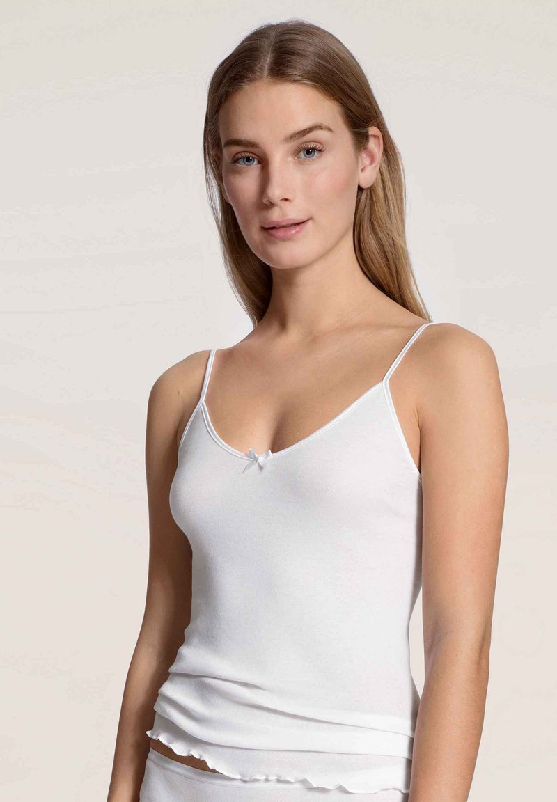 Witte mouwloze camisole met dunne bandjes, V-vormige halslijn en een klein strikje in het midden, met een geribbelde textuur en een gerimpelde zoom.