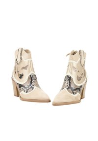 Botas de tobillo beige con una mezcla de ante y patrón de serpiente, punta afilada y tacón cuadrado. Costuras decorativas a lo largo de los bordes.