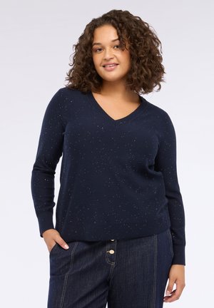 Maglione a V in navale realizzato in morbido tessuto a maglia con accenti dorati. Caratterizzato da maniche lunghe e un fit rilassato. Abbinato a jeans scuri.