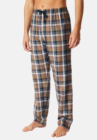 Geruite pyjamabroek in bruin, blauw en wit, met een elastische tailleband met trekkoord en een losse pasvorm. Zachte katoenen stof.