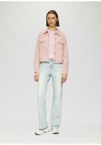 Korte roze tweedjas met twee borstzakken, gecombineerd met lichtblauwe rechte jeans en grijze sneakers. Soepele texturen, casual ontwerp.
