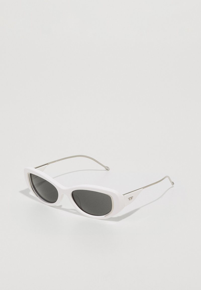 Gafas de sol de plástico blanco con una montura elegante y angular. Lentes oscuros y brazos de metal plateado presentan una ligera curva para mejorar el agarre.