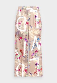 Weite, beige Hosen mit einem mehrfarbigen Blumenmuster und großen weißen Buchstaben. Elastischer Bund und weiche Stoffstruktur.