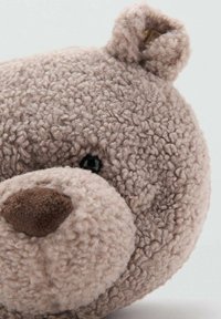 Orso di peluche marrone con una superficie testurizzata e pelosa; presenta orecchie rotonde, occhi neri e un naso morbido e marrone.