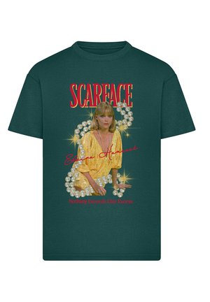 Zöld pamut póló, amelyen egy arany ruhás, gyöngyös díszítésű nő grafikai mintája látható, valamint a "SCARFACE" felirat piros betűkkel.