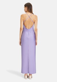 Lilafarbene Satin-Maxikleid mit tiefem Rückenausschnitt, überkreuzten Trägern und gerader Silhouette. Glatte Textur und minimale Hardware-Details.