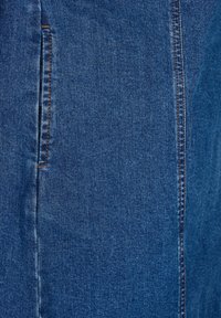 Denim tkanina u tamnoplavoj boji, s vidljivim šavovima i bočnom džepom, glatke teksture i klasičnog dizajna traperica.