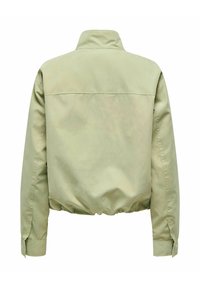 Veste beige clair à manches longues, taille élastique et col montant vue de dos sur fond blanc.
