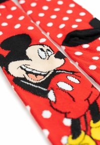 Calze rosse con pois bianchi, caratterizzate da un design di un personaggio dei cartoni animati in bianco e nero di Topolino. Realizzate in tessuto lavorato a maglia.