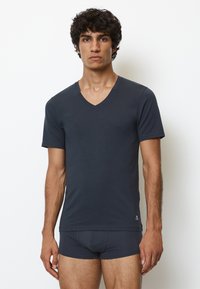 Mørkegrå tætsiddende V-hals t-shirt lavet af blødt stof, parret med matchende boxershorts. Simpelt design uden mønstre eller accenter.