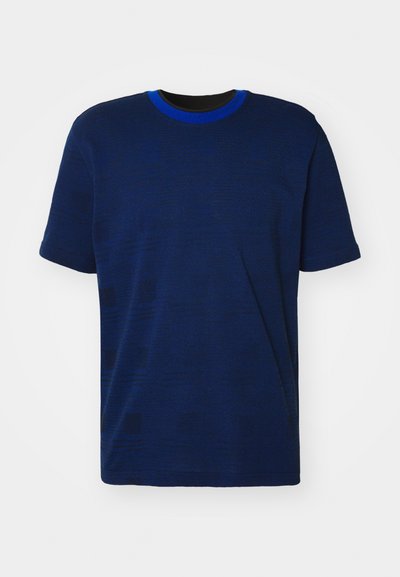 Mørkeblå t-skjorte med rund hals og korte ermer. Har et teksturert stoff med subtile mønstre. Kantet i kongeblå.