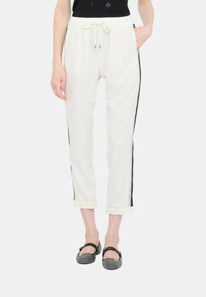 Pantaloni da jogger bianchi con strisce nere laterali, dotati di una vita con cordino e orli a coste. Tessuto liscio con una finitura casual.