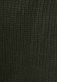 Pletená látka v tmavě zelené barvě s vroubkovanou strukturou a svislými liniemi. Materiál působí měkce a hustě, s mírným leskem.