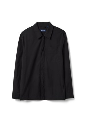 Chemise noire à manches longues avec boutons sur le devant, col pointu et poche poitrine, étalée à plat sur fond blanc.