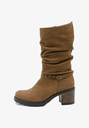 Botine din suede maro, cu partea superioară căzută, accent cu curea cu ținte și toc cu straturi. Textură netedă și design cu vârf rotunjit.