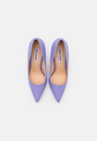 Purple stiletto heels with a smooth finish, pointed toe design, and cut-out sides. Inner lining is a tan color. Brand label visible inside.