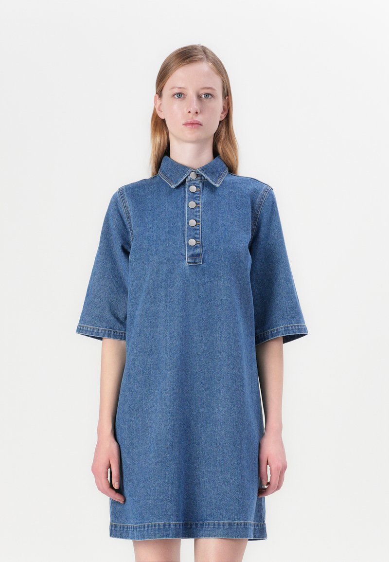 Denimkjole med knapp-up krage, korte ermer, fem knapper foran og en avslappet passform. Har en ren, ensfarget blå farge og kant.