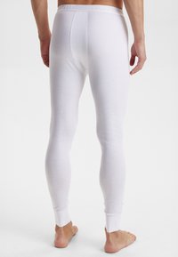 Hvide bomulds lang undertøj med en tætsiddende design, elastisk talje og ribbede manchetter. Blød tekstur og glat overflade.
