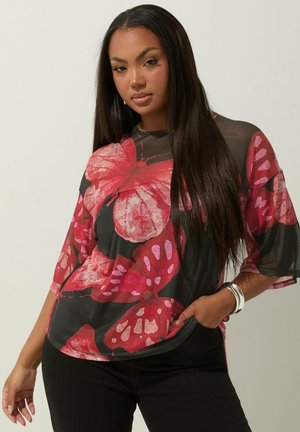 Top nero trasparente con ampia stampa floreale rosa, maniche larghe, vestibilità ampia e scollo rotondo. Presenta una texture liscia e colori vivaci.