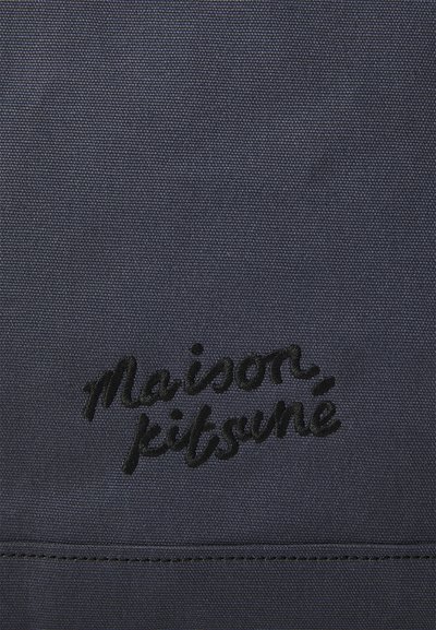 Tengerészkék szövetvászon, középen kiemelkedő fekete hímzett "maison kitsuné" felirattal, sima textúrával és varrási részletekkel.