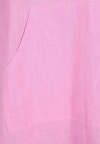 Ljust rosa linne tyg med en framficka och mjuk textur, med synlig sömnad längs kanterna som förmedlar en avslappnad design.