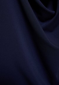 Tkanina temno modre barve z gladko teksturo, ki ima subtilen rebrast vzorec in mehko padajočo draperijo. Brez vidnih okov ali poudarkov.