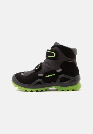 Black and green hiking boot with Velcro straps, textured sole, and ankle support, designed for outdoor activities.