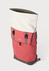 Rød og beige rullesekk med grå detaljer, glidelåslomme, justerbare stropper og logo på frontpanelet. Slitesterk stofftekstur.