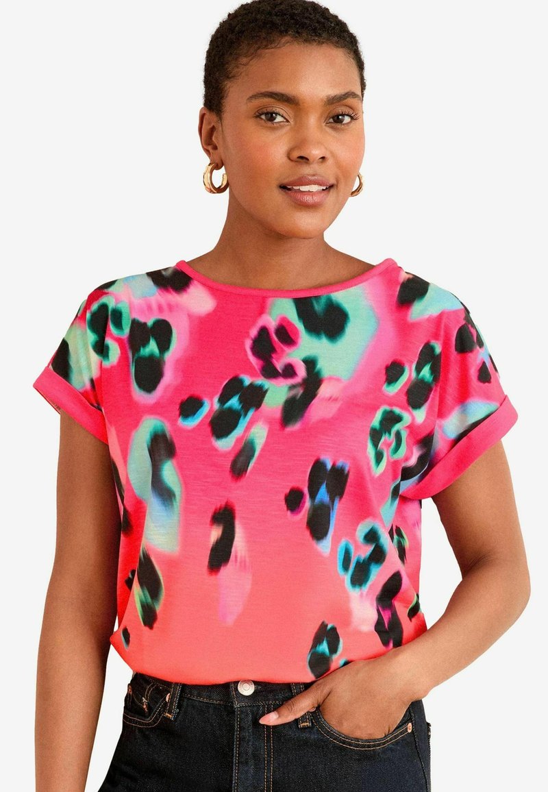 Krátky rukáv top v žiarivej ružovej farbe s abstraktným leopardím vzorom v čiernej a tealovej farbe. Mäkkučký materiál, okrúhly výstrih a voľný strih.