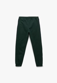 Groene joggingbroek met een zachte textuur, een elastische tailleband en marineblauwe zijkanten, met taps toelopende boorden bij de enkels.