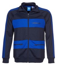 Herr zip-up jacka i marinblå polyester med blå horisontella ränder. Har broderad logotyp, fickor med dragkedja och ribbade ärmslut.