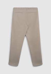 Pantaloni beige su misura con cintura elastica, due tasche posteriori a filetto e gambe affusolate che terminano in polsini stretti, mostrati da dietro.