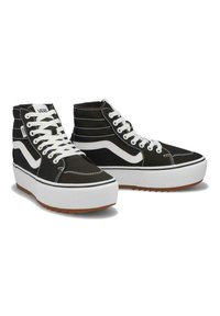 Zapatillas altas negras con costuras blancas, con una franja lateral blanca y una suela gruesa blanca. Tejido texturizado y suela de goma.