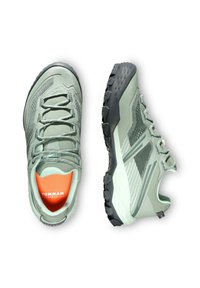 Ljust gröna trailrunning-skor med meshuvdel, orange innersula och svart gummisula med djupa mönster för bra grepp.
