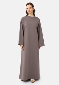 Robe longue grise en tissu lisse, avec des manches longues, un col rond et une coupe ample, atteignant les chevilles.