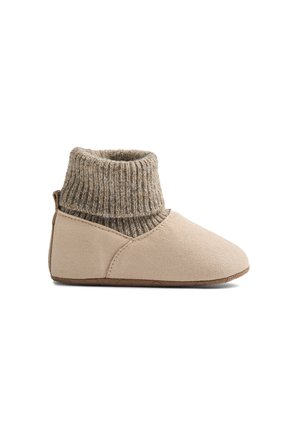 Beige baby hjemmesko med blød sål og kraftig ribstrikket ankelmanchet, set fra siden mod hvid baggrund.
