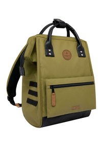 Sac à dos vert olive avec des accents en cuir noir, deux poignées supérieures, des bretelles réglables, une poche zippée à l'avant et un fond texturé.
