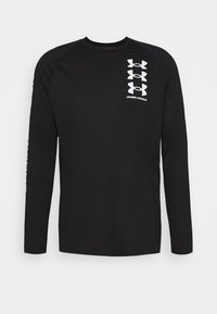Czarna koszulka z długim rękawem i rękawami raglanowymi, z białym graficznym logo na klatce piersiowej i na lewym rękawie. Miękka faktura materiału.
