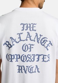 Witte katoenen T-shirt met op de achterkant marineblauwe gebarsten tekst "THE BALANCE OF OPPOSITES RVCA".