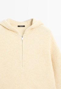 Maglione beige con cappuccio e mezza zip, realizzato in tessuto a costine, dotato di tasca a marsupio e una consistenza morbida. L'etichetta riporta "Massimo Dutti."