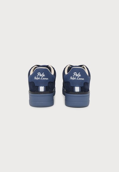 Ζευγάρι navy μπλε αθλητικά παπούτσια Polo Ralph Lauren, φαίνονται από πίσω, με λευκό λογότυπο και λευκή κάθετη ρίγα σε κάθε τακούνι.