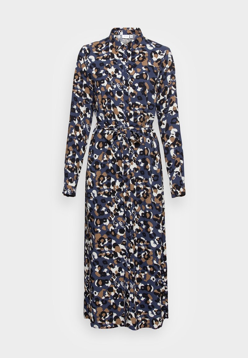 Košilové šaty s dlouhým rukávem a knoflíkovým zapínáním, pokryté modrým, hnědým, černým a bílým abstraktním leopardím vzorem, s látkovým páskem uvázaným v pase.