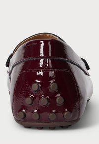 Burgundské lakované loafery s hladkým povrchom, so štruktúrovanou podrážkou s okrúhlymi hrotmi pre lepšiu priľnavosť. Elastické detaily na stranách.